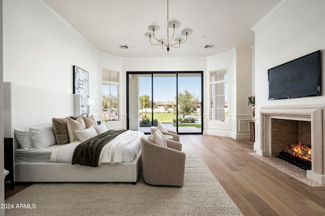 bedroom featuring a chandelier, access to outside, light hardwood / wood-style flooring, and crown molding