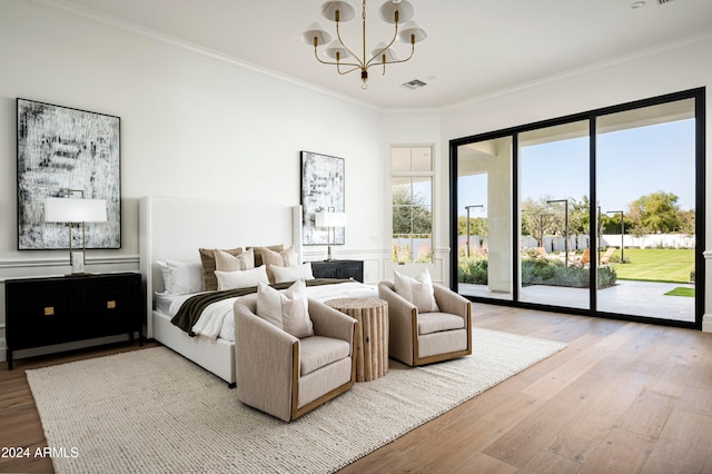 bedroom featuring access to exterior, an inviting chandelier, light hardwood / wood-style floors, and ornamental molding