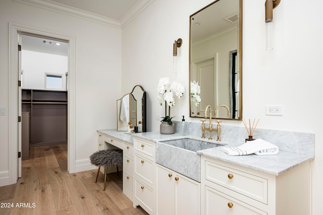 bathroom with wood-type flooring, vanity, and crown molding