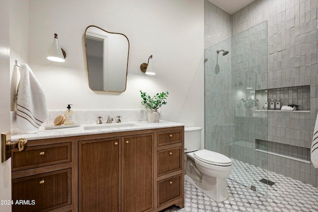 bathroom featuring tiled shower, vanity, and toilet