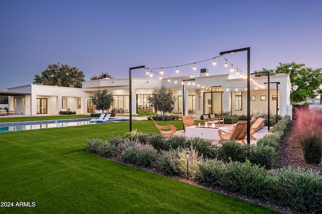 view of property's community featuring a lawn, a patio, and a pool