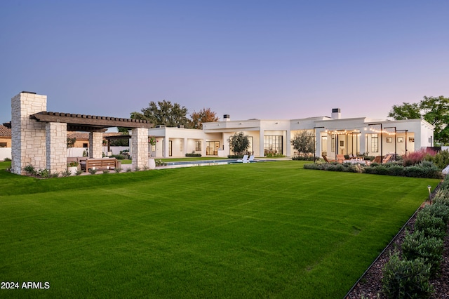 back house at dusk featuring a yard