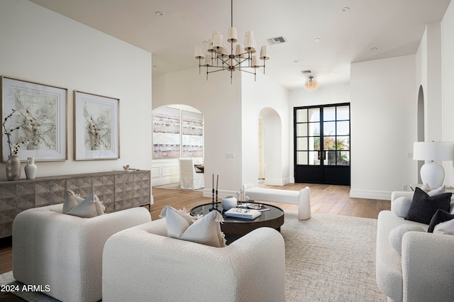 living room with light hardwood / wood-style floors and a notable chandelier