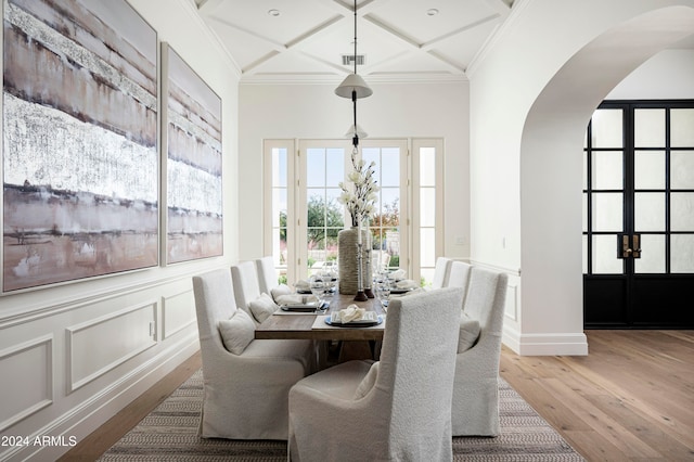 dining room featuring hardwood / wood-style floors, coffered ceiling, and ornamental molding