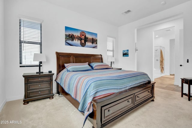 carpeted bedroom with multiple windows and ensuite bathroom