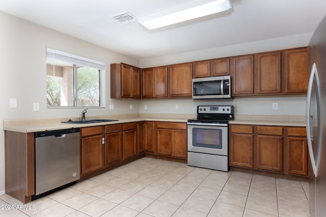 kitchen featuring appliances with stainless steel finishes, sink, and light tile patterned floors