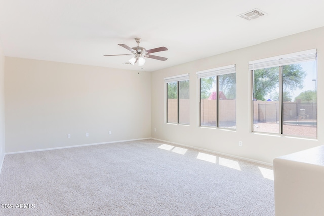 spare room with ceiling fan and light carpet