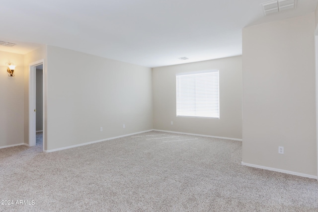 spare room featuring light colored carpet