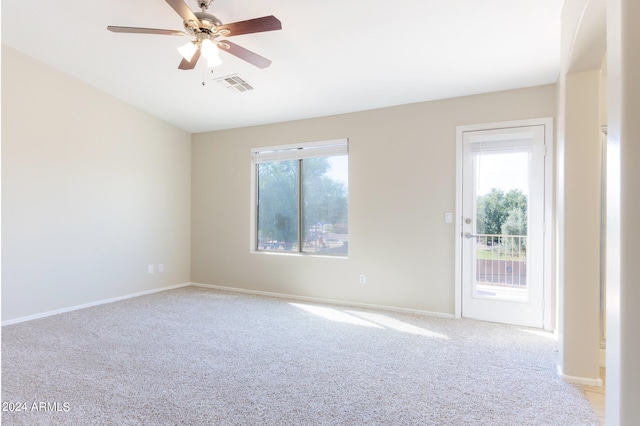 unfurnished room featuring ceiling fan, light colored carpet, and plenty of natural light