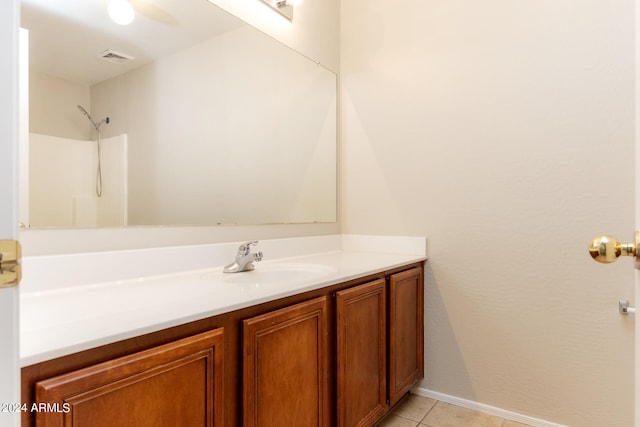 bathroom with walk in shower, vanity, ceiling fan, and tile patterned floors