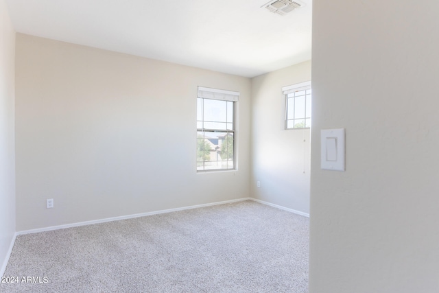 unfurnished room featuring light carpet