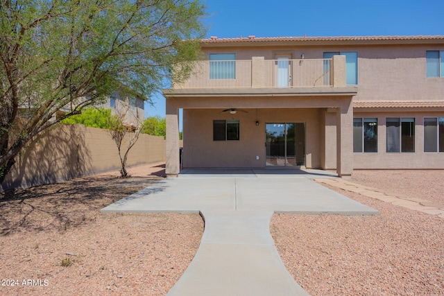 rear view of property featuring a balcony, a patio, and ceiling fan