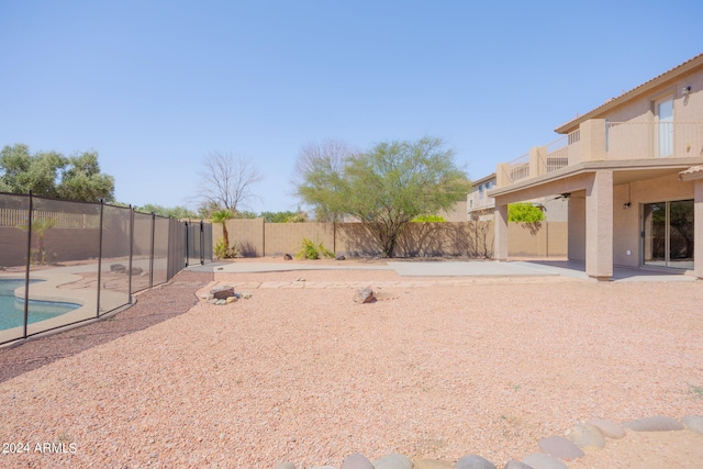 view of yard featuring a balcony, a patio, and a fenced in pool