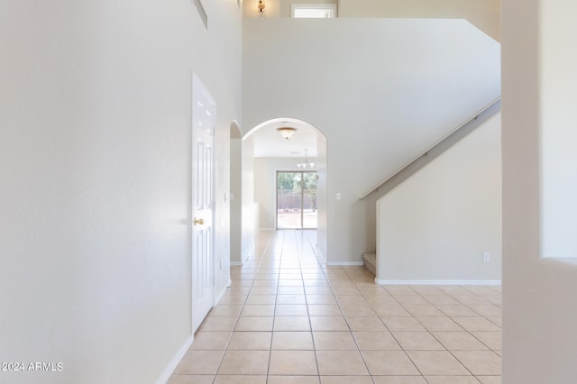 interior space with a towering ceiling and light tile patterned flooring