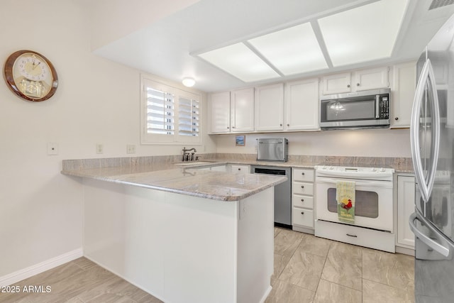 kitchen with stainless steel appliances, white cabinetry, sink, and kitchen peninsula