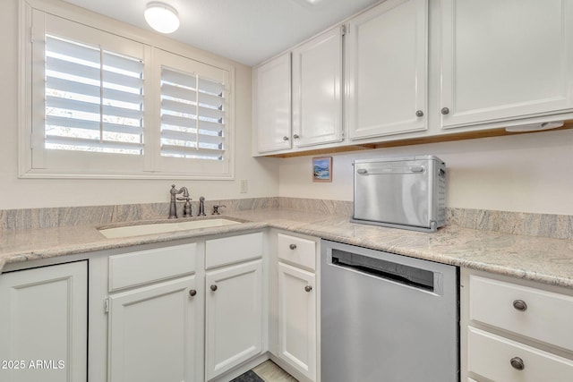 kitchen with dishwasher, sink, white cabinets, and light stone counters