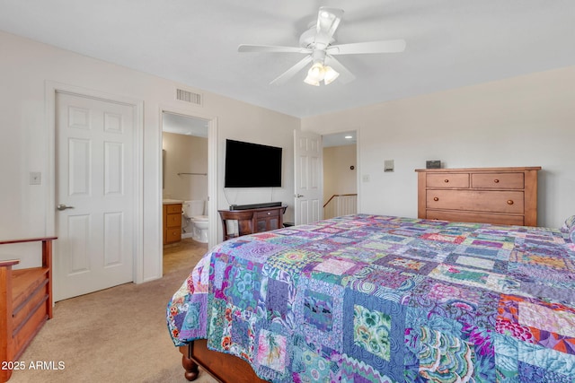 bedroom with light carpet, ceiling fan, and ensuite bath