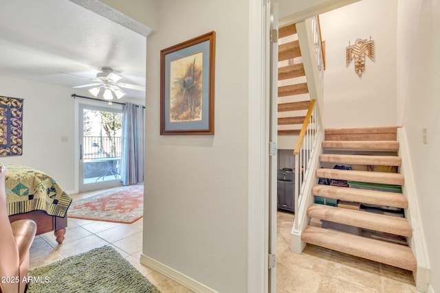 staircase featuring ceiling fan