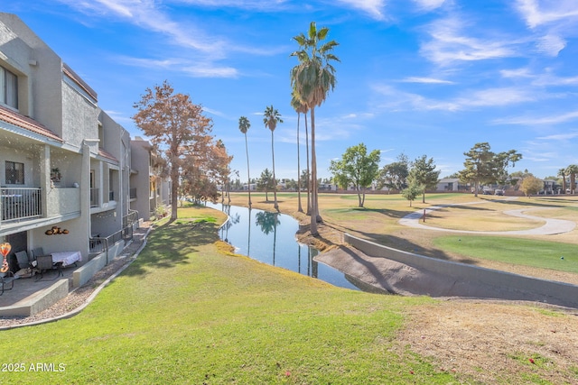 view of property's community with a yard and a water view