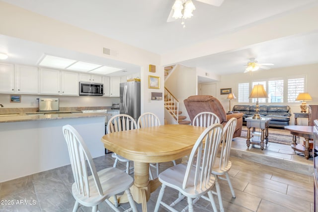 dining space featuring ceiling fan and sink