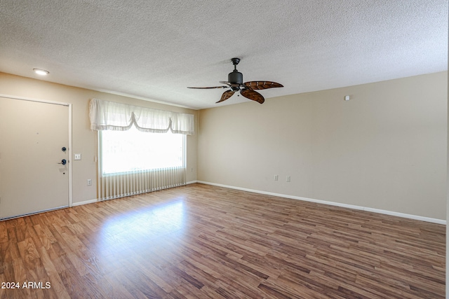 empty room featuring ceiling fan, a textured ceiling, and hardwood / wood-style flooring