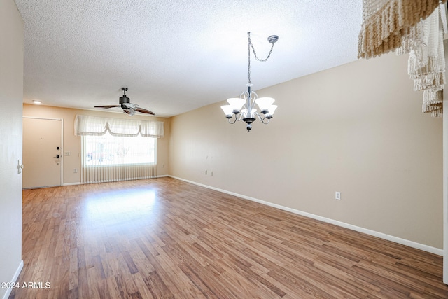 spare room with hardwood / wood-style floors, ceiling fan with notable chandelier, and a textured ceiling