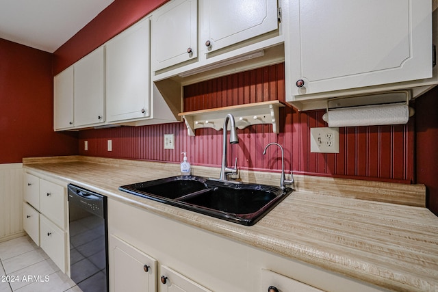 kitchen featuring white cabinets, sink, light tile patterned floors, and black dishwasher