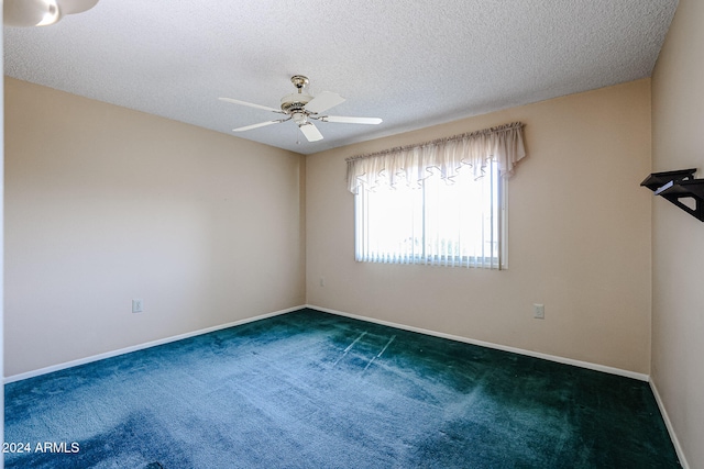 carpeted spare room featuring ceiling fan and a textured ceiling