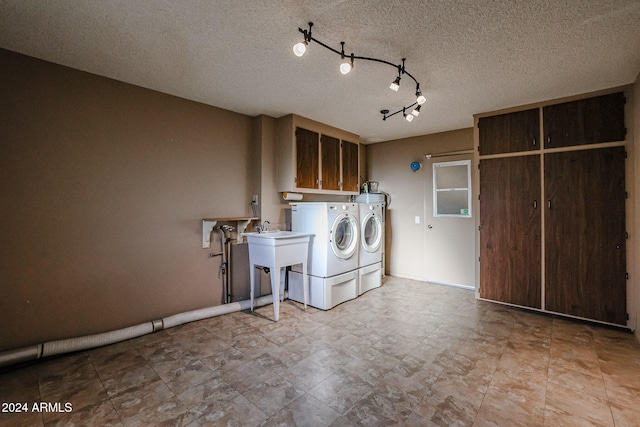 washroom featuring cabinets, a textured ceiling, separate washer and dryer, and sink