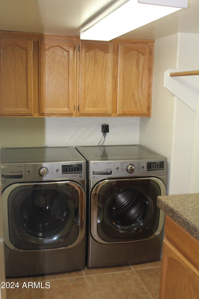 laundry room featuring cabinets, separate washer and dryer, and light tile floors