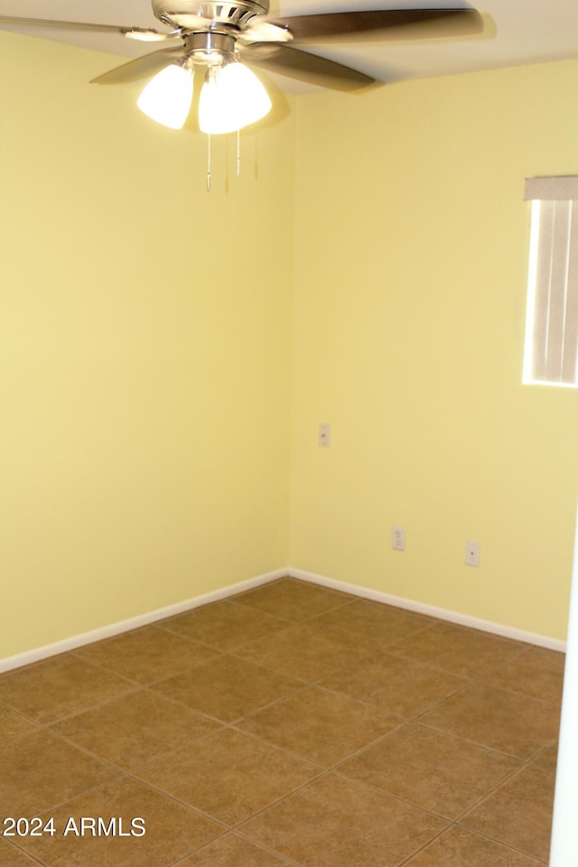 tiled spare room featuring ceiling fan