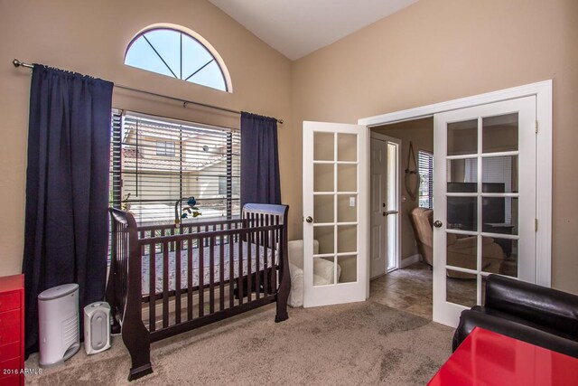 bedroom featuring french doors, a nursery area, high vaulted ceiling, and carpet flooring