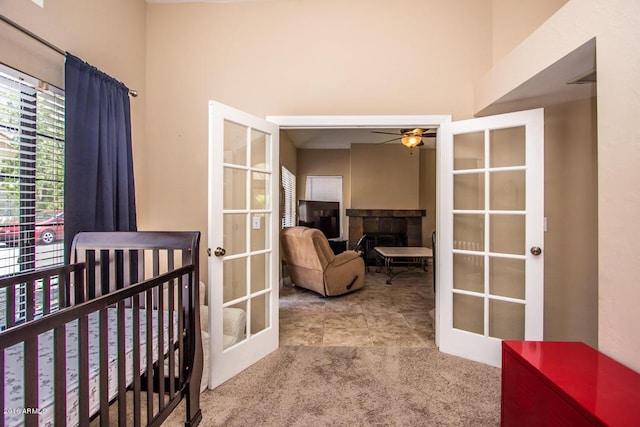 carpeted bedroom featuring french doors and a nursery area