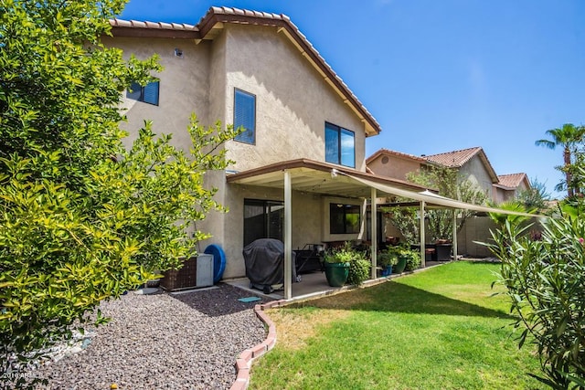 back of property with a patio area and a lawn