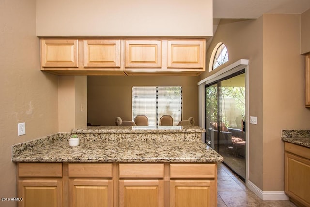 kitchen featuring kitchen peninsula and light brown cabinetry