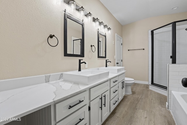 full bathroom with hardwood / wood-style floors, vanity, separate shower and tub, and toilet