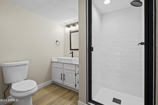 bathroom featuring vanity, a shower, toilet, a textured ceiling, and wood-type flooring