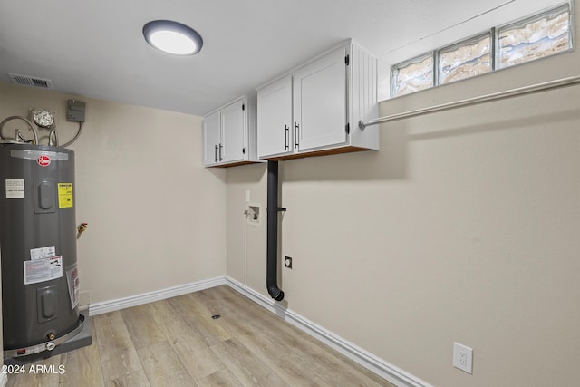 washroom with visible vents, electric water heater, cabinet space, light wood finished floors, and baseboards