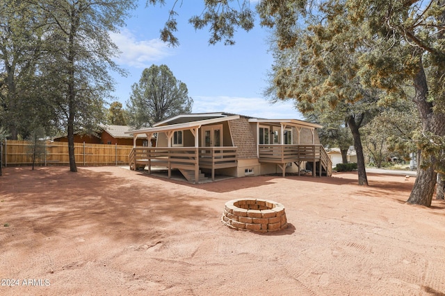 rear view of house with a deck, stairs, fence, and an outdoor fire pit