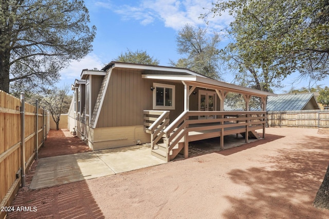 exterior space featuring a patio area, a fenced backyard, french doors, and a wooden deck