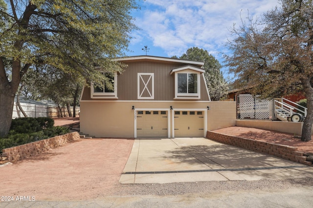 view of front facade with concrete driveway and fence