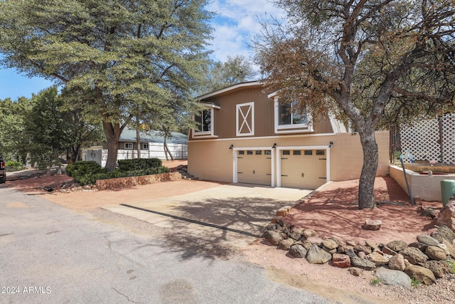 view of front of home featuring stucco siding, an attached garage, and driveway