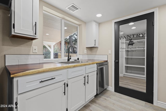 kitchen with white cabinets, dishwasher, and sink