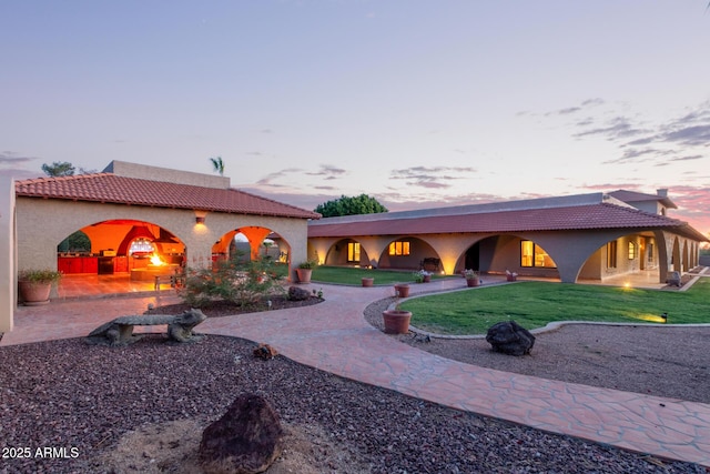 8043 E Laurel St, Mesa, AZ 85207 - back of property at dusk with a yard, a tile roof, stucco siding, and a patio area