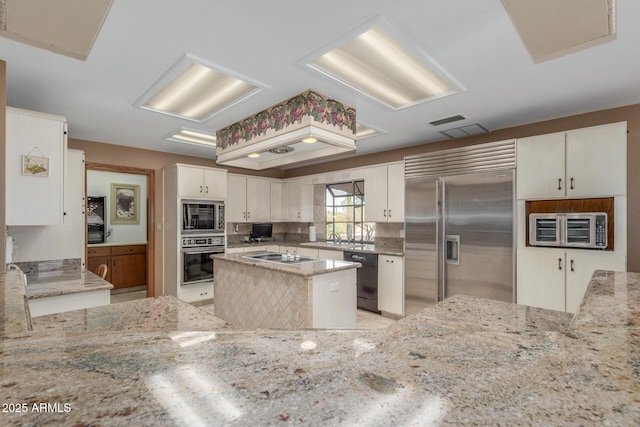 8043 E Laurel St, Mesa, AZ 85207 - kitchen with built in appliances, light stone counters, decorative backsplash, white cabinetry, and light tile patterned floors