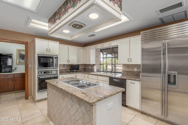 8043 E Laurel St, Mesa, AZ 85207 - kitchen featuring built in appliances, decorative backsplash, light tile patterned floors, a raised ceiling, and white cabinets