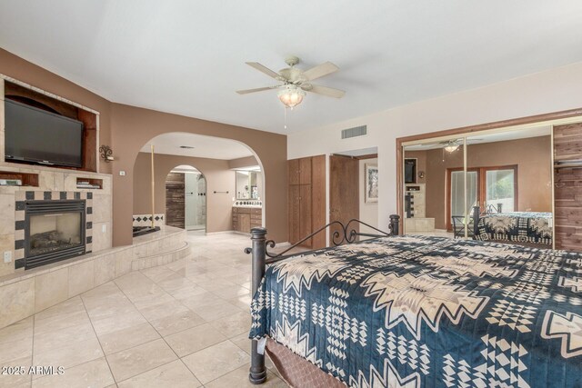 8043 E Laurel St, Mesa, AZ 85207 - bedroom with a fireplace, tile patterned flooring, arched walkways, a ceiling fan, and connected bathroom