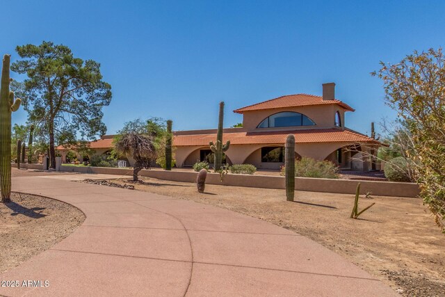 8043 E Laurel St, Mesa, AZ 85207 - mediterranean / spanish home with a tiled roof, stucco siding, a chimney, and curved driveway