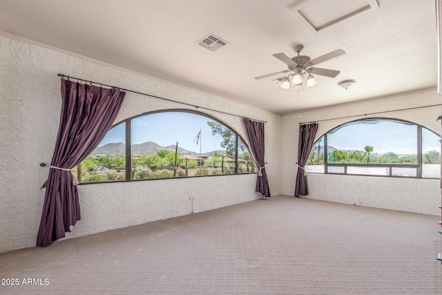 8043 E Laurel St, Mesa, AZ 85207 - empty room featuring carpet flooring, a textured wall, a mountain view, and a ceiling fan