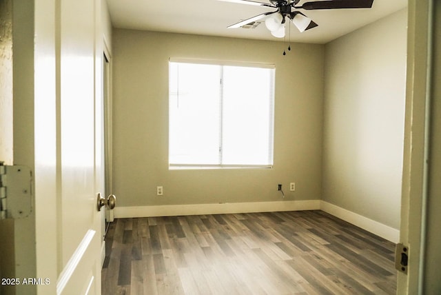 empty room featuring ceiling fan and dark hardwood / wood-style flooring